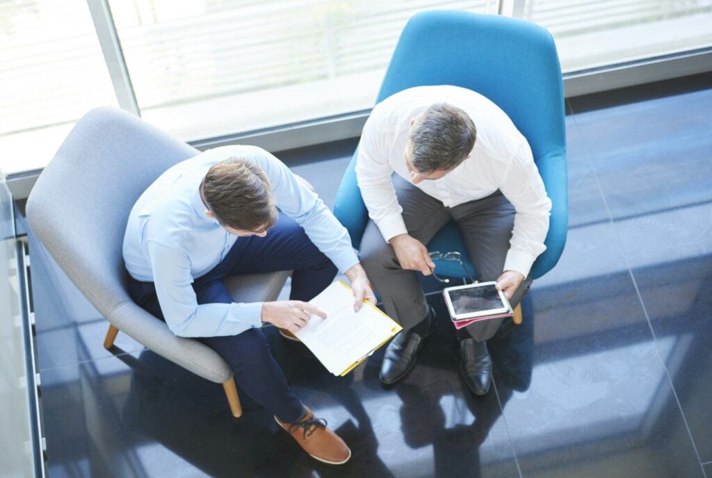 Overhead view of business men with digital tablet in meeting