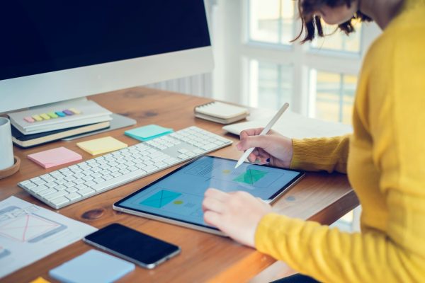 Designer woman drawing a website outline and website ux app development on mobile phone.